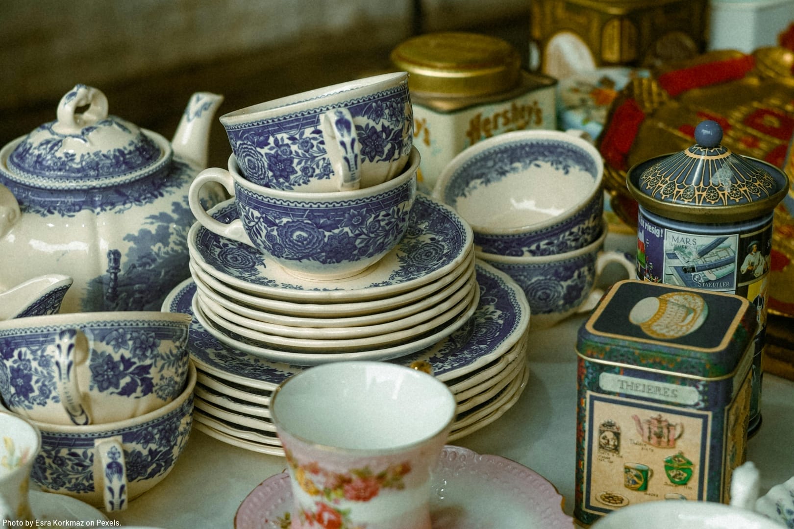 vintage tea set and other fine china on display at a flea market representing what millennials do when they inherit tons of stuff