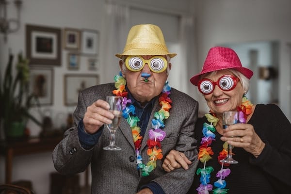 Senior Couple Drinking And Wearing Novelty Glasses At A Party