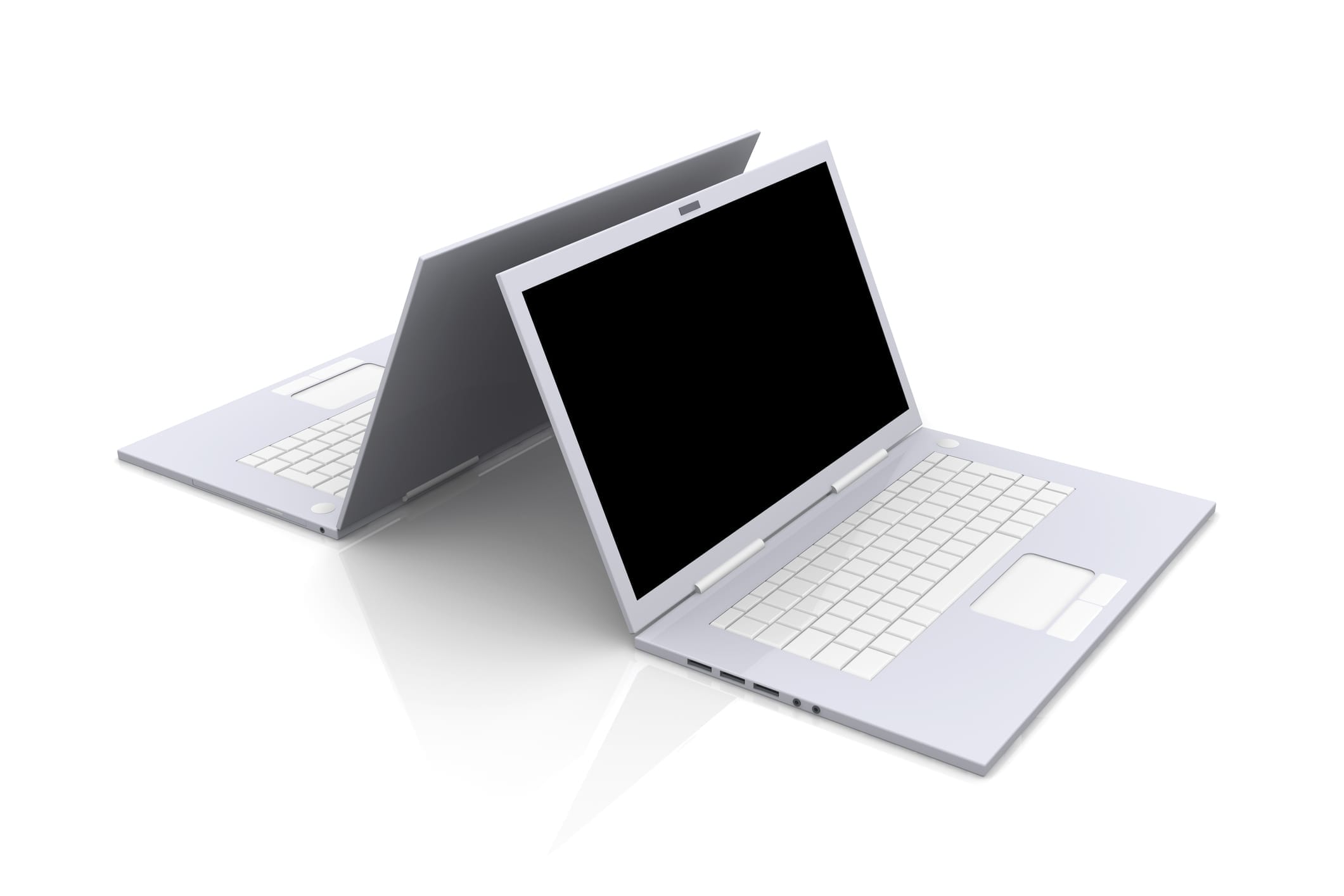 Two silver laptops positioned back-to-back with open screens and keyboards facing opposite directions on a reflective surface.