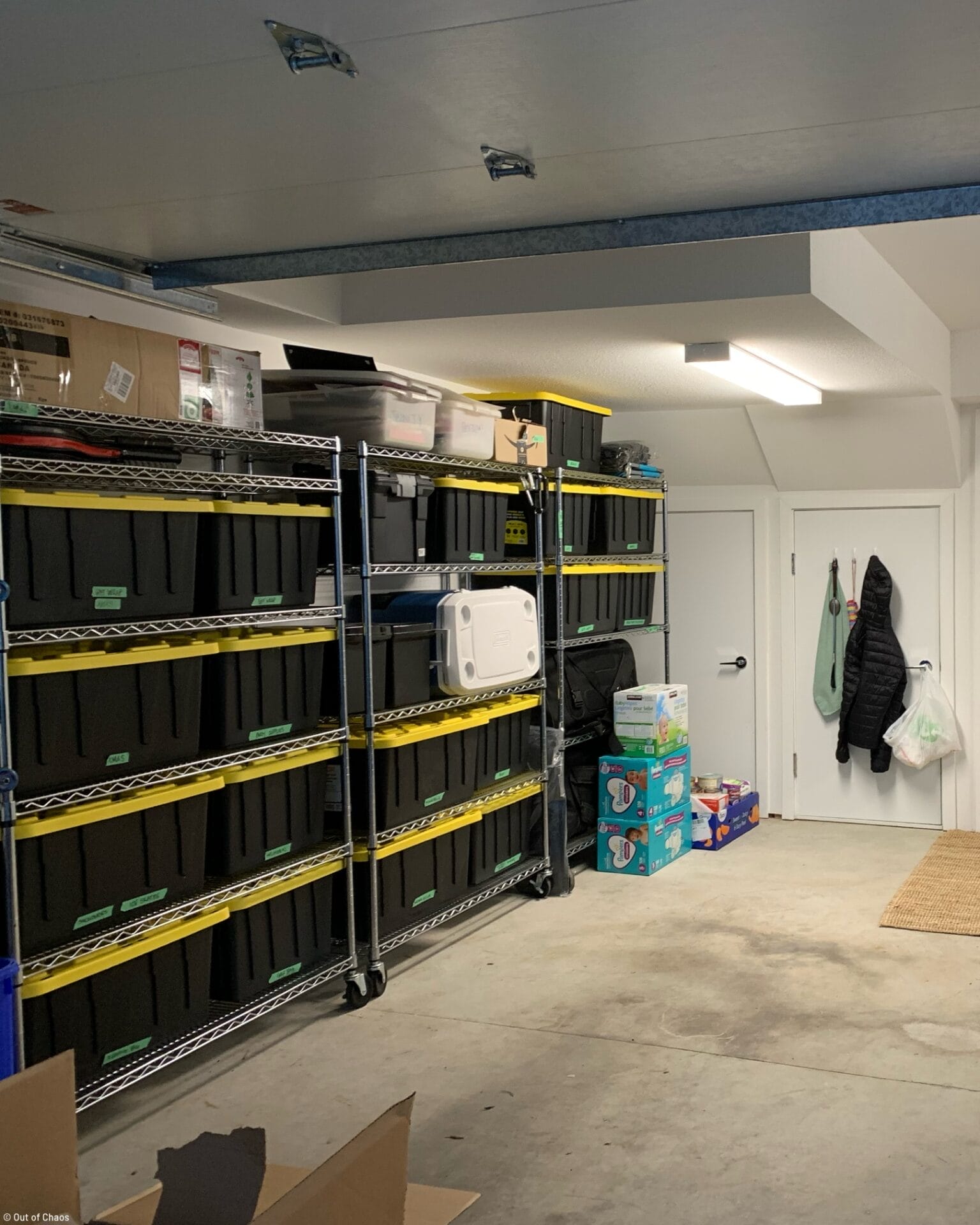 black bins with yellow lids stacked neatly on stainless steel shelving